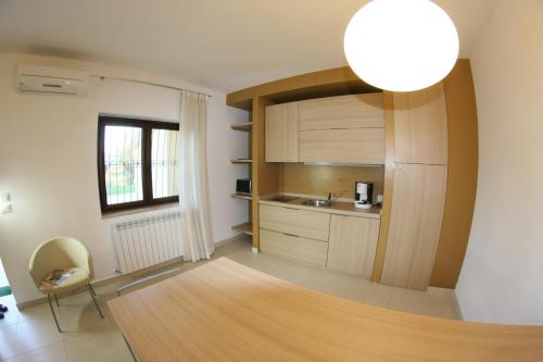 a kitchen with wooden cabinets and a table at San Michele Apartments&Rooms in Catanzaro