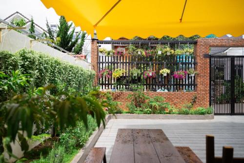 a garden with a black fence and flowers at Thé Villa in Da Lat