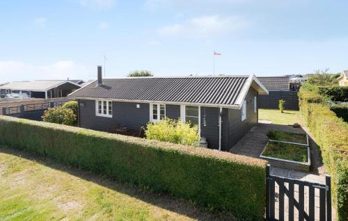 a small blue house with a hedge in front of it at Gorgeous Home In Karrebæksminde in Karrebæksminde