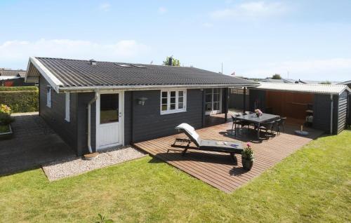 a tiny house with a deck and a table at Gorgeous Home In Karrebæksminde in Karrebæksminde