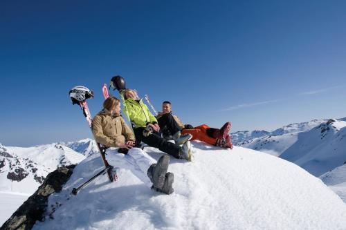 a group of people sitting on top of a snow covered mountain at Apart Christine in Aschau