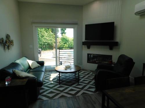 a living room with a couch and a table and a television at Angies Oasis in San Ramon