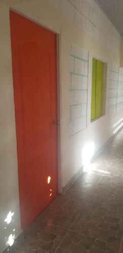 a red door in a room with two paintings on the wall at Villa Marina in Moñitos