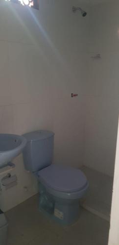 a bathroom with a blue toilet and a sink at Villa Marina in Moñitos