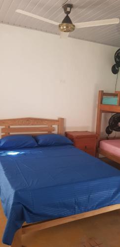 a bedroom with a blue bed and a chair at Villa Marina in Moñitos