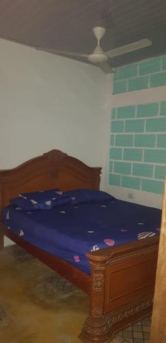 a bedroom with a bed with blue sheets and a brick wall at Villa Marina in Moñitos