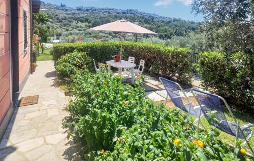 a garden with a table and chairs and an umbrella at Amazing Apartment In Recco With Kitchen in Recco