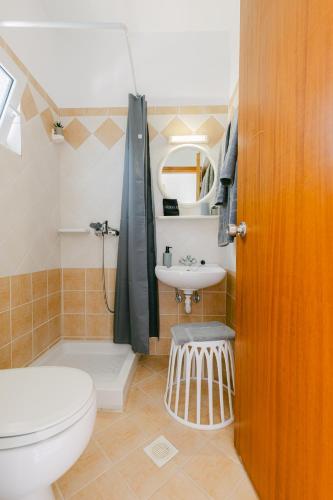 a bathroom with a toilet and a sink at Andimesia orae in Kámpos