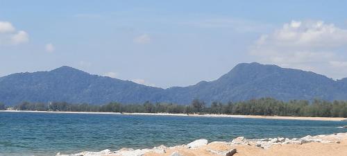 a large body of water with mountains in the background at Chatak Hill Residence in Dungun