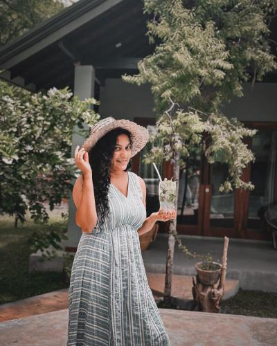 a woman wearing a hat and holding a drink at Maritime Nest Cabanas in Tangalle