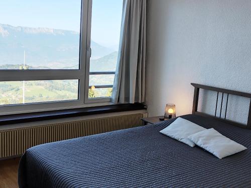 une chambre avec un lit et deux fenêtres dans l'établissement Appartement spacieux, coeur de station, jusqu'à 6 pers, équipé et proche remontées mécaniques - FR-1-771-75, à Les Adrets