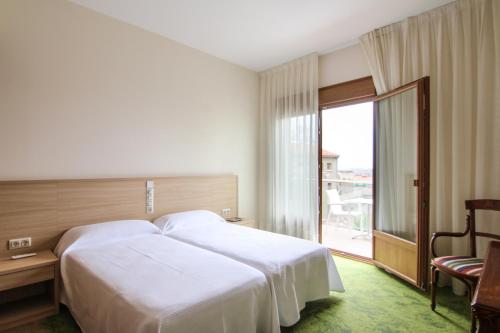 Habitación de hotel con cama grande y ventana en Hotel Cal Piteu, en Guisona