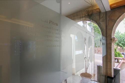 a white wall with a sign on the side of a building at Hotel Cal Piteu in Guisona