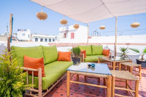 ein Wohnzimmer mit einem grünen Sofa und einem Tisch in der Unterkunft Dar Sekka in Tangier