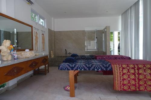 a bedroom with two beds and a sink and a mirror at The Villa Pantai in Temukus
