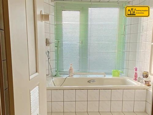 a white tub in a bathroom with a window at Moon River Court - Vacation STAY 19871v in Fujiyoshida