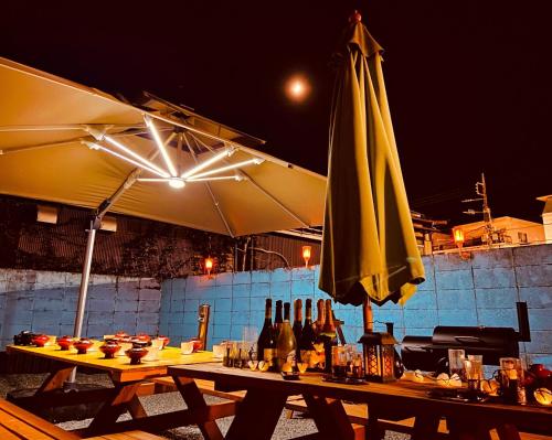 a table with an umbrella and bottles of wine at Moon River Court - Vacation STAY 19871v in Fujiyoshida