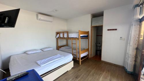 a small room with a bed and a bunk bed at El Rincón de Don Javier Casa de Playa in El Platano