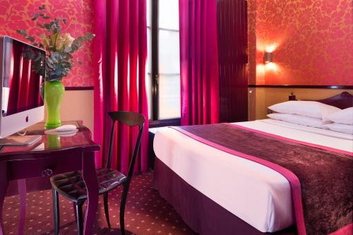 a hotel room with a bed and a table and a desk with a computer at Hotel Design Sorbonne in Paris