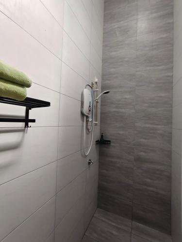 a shower stall in a bathroom with white tiles at Sakeenah Homestay near UUM, UNIMAP and Matrik Kedah in Changlun