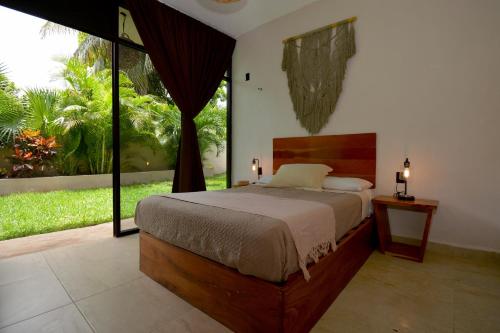 a bedroom with a bed and a large window at Casa Delia Hotel Downtown in Bacalar