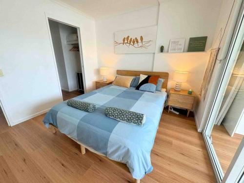 a bedroom with a large bed with a blue comforter at Spacious Apt with pool & parking in Brisbane