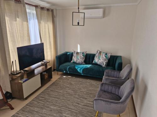 een woonkamer met een groene bank en 2 stoelen bij Hermosa casa en pucon in Pucón