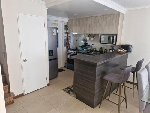 een keuken met een aanrecht en een aantal stoelen. bij Hermosa casa en pucon in Pucón