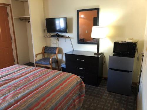a hotel room with a bed and a television at Gratiot View Motel in Saginaw