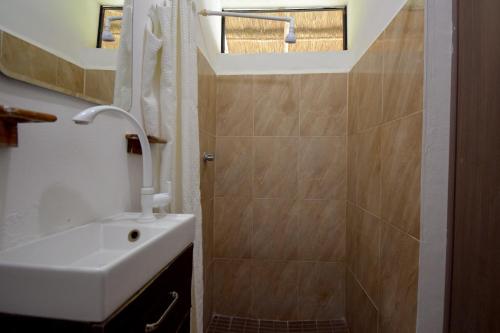 a bathroom with a sink and a shower at Casa Delia Hotel Downtown in Bacalar