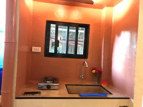 a kitchen counter with a sink and a window at Sun House Rental in Mambajao