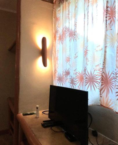 a computer monitor on a desk in front of a window at Sun House Rental in Mambajao
