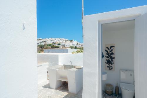 a white bathroom with a sink and a toilet at Rena's Dream in Artemonas