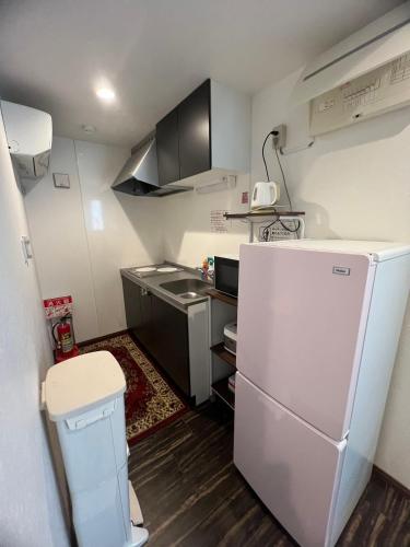 a small kitchen with a refrigerator and a sink at 民泊TOKYO one シェアハウス in Tokyo