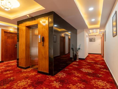a hallway with a door and a red carpet at Naksel Urban Hotel & Spa in Thimphu
