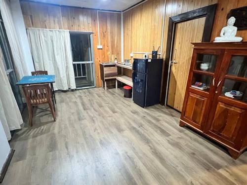 a room with a desk and a kitchen with wooden walls at The Hideaway-Kandy in Kandy