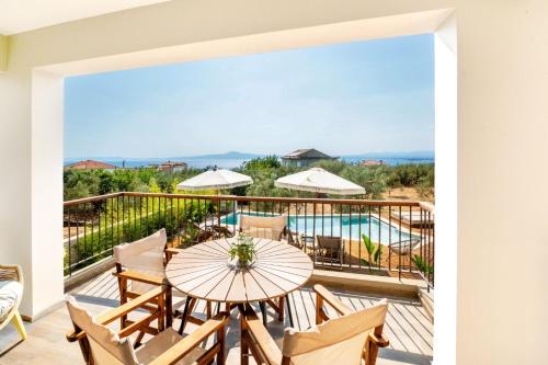 a balcony with a table and chairs and a pool at Petradi Suites in Kalamata