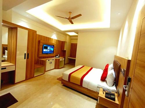 a bedroom with a bed and a ceiling fan at Hotel MASAGA by QCENT in Gurgaon