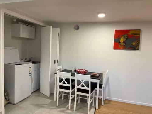 a kitchen with a table and chairs in a room at Peaceful and convenient in Auckland
