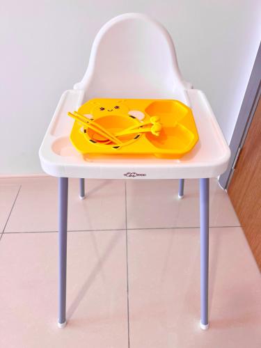 a white chair with a yellow tray on it at Legoland-3mins Drive KUROMI FAMIY SUITE in Iskandar Puteri