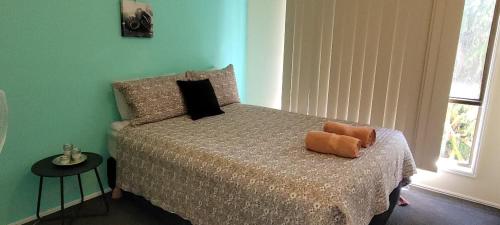 Dormitorio con cama con almohada naranja en Roo Or 2 on Streeter, en Agnes Water