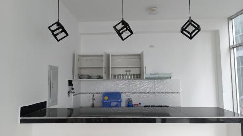 a kitchen with white walls and a counter top at Plateia - Casa de Playa en Zorritos in Bocapán