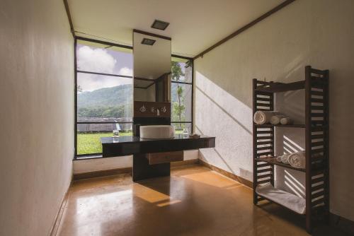 a bathroom with a sink and a large window at Rainforest Resort in Athirappilly