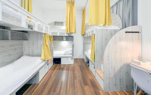 a small room with two beds and yellow curtains at 笑脸里青年旅舍宽窄店 in Chengdu