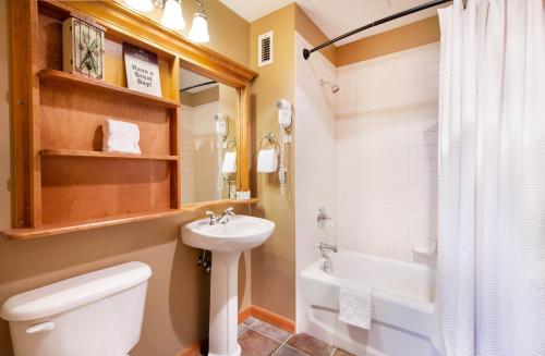 a bathroom with a toilet and a sink and a tub at Select Unit 1710 - 2BR - Zephyr Mountain Lodge condo in Winter Park