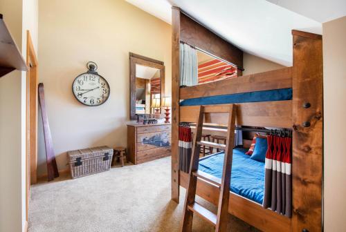 a bedroom with a bunk bed and a clock on the wall at Select Unit 1710 - 2BR - Zephyr Mountain Lodge condo in Winter Park