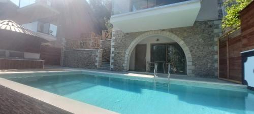 a swimming pool in front of a house at Filoxenia Sea View in Parga