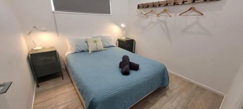 un dormitorio con un osito de peluche sentado en una cama en Ohana Hawaiian term meaning family, en Agnes Water