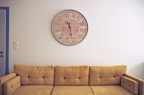 un grand réveil sur un mur au-dessus d'un canapé dans l'établissement L'escale 67, à Strasbourg