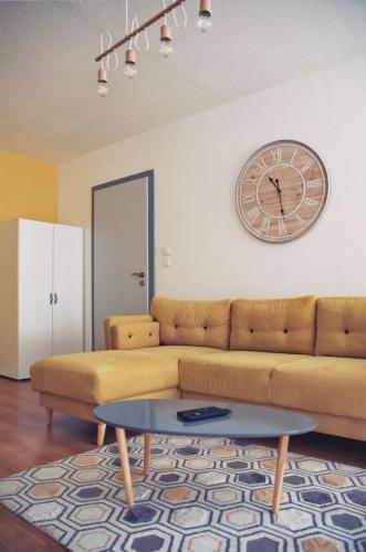 un salon avec un canapé et une horloge au mur dans l'établissement L'escale 67, à Strasbourg